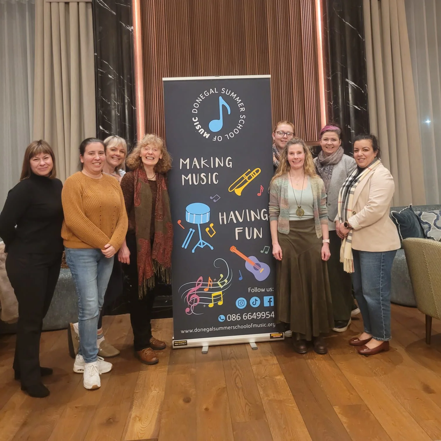 The DSSM committee members standing with the Donegal Summer School of Music banner