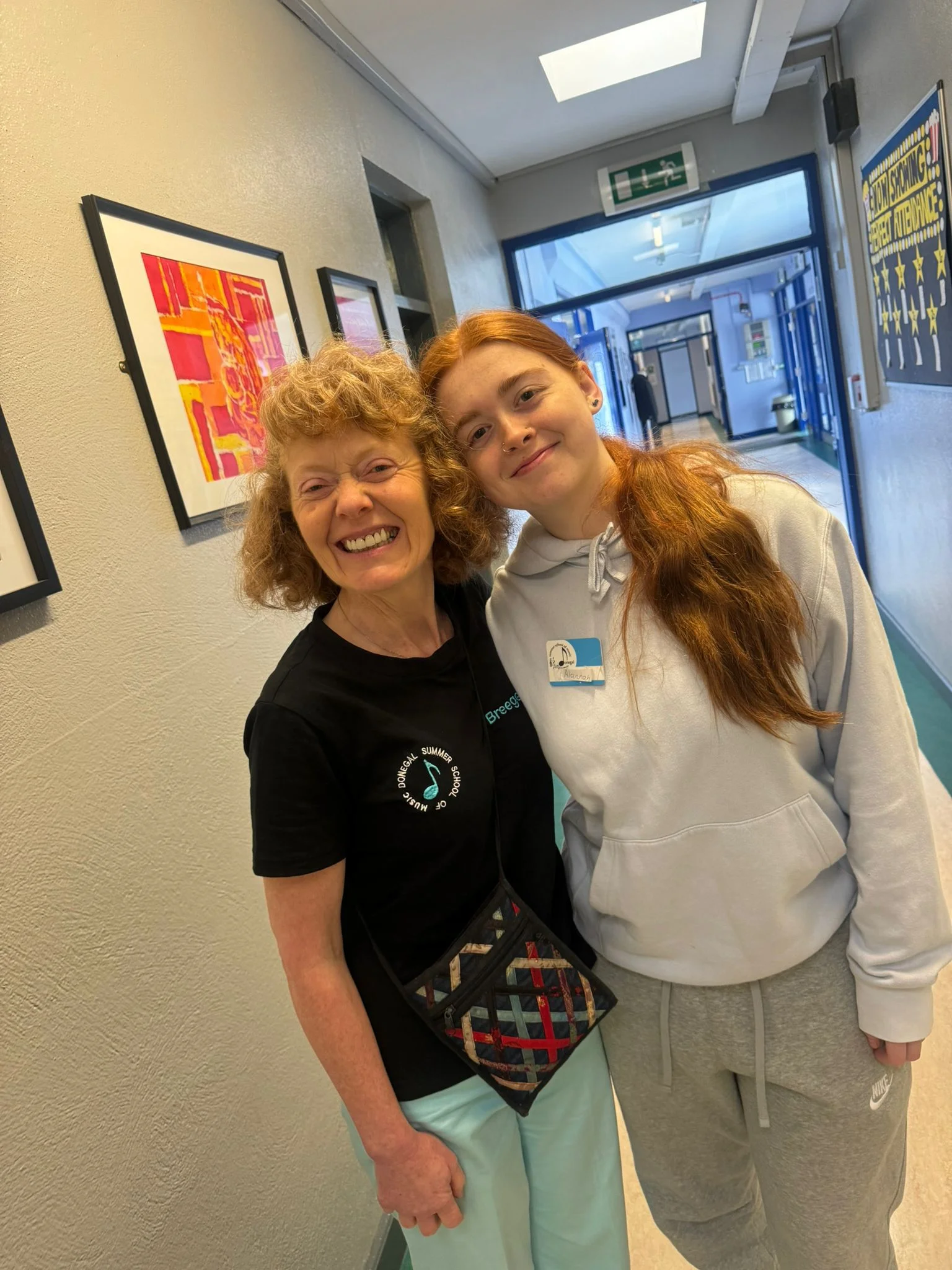 Tutor and student smiling together in the school corridor