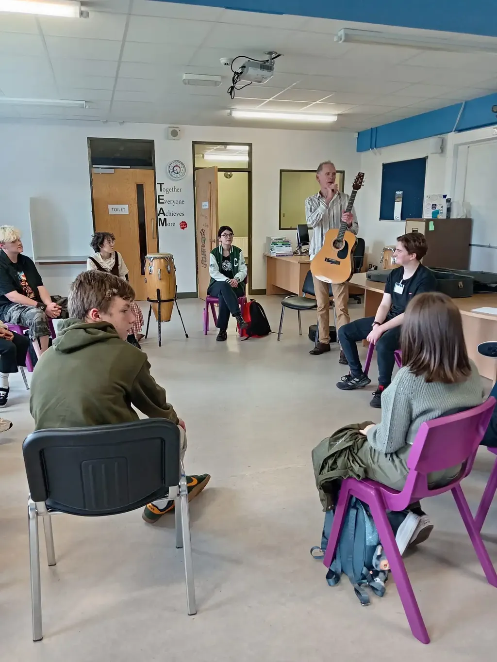 Guitar instructor teaching an ensemble of young students at DSSM